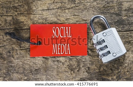 Combination number padlock on wood background with Social Media written on label tag