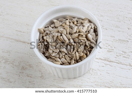 Peeled sunflower seeds on the wood background