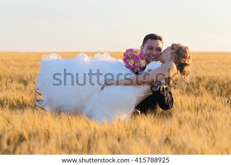 groom and bride posing in the field