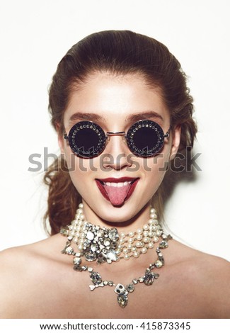 Lifestyle portrait Urban fashion girl on white background. woman in vogue sunglasses professional make-up doing funny face 