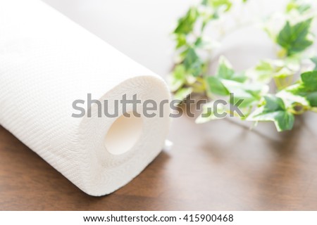 Roll of paper towel on wooden background