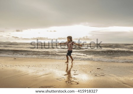 Unidentified young girl playing at the beach on late evening