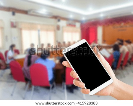 woman use mobile and blurred image of people in meeting room