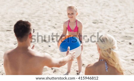 family, summer vacation, adoption and people concept - close up of happy man, woman and little girl playing with inflatable ball on beach