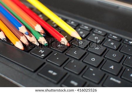 Wooden crayons on black computer keyboard.
