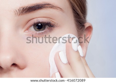 Woman using cotton pad. Happy smiling beautiful young woman cleaning skin by cotton pad. light background. Beautiful Spa Woman Smiling. Perfect Fresh Skin. Youth and Skin Care Concept Royalty-Free Stock Photo #416072089