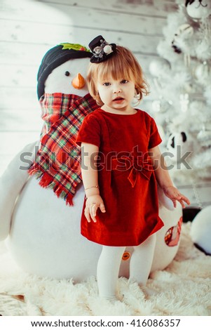 girl in a red dress with a snowman