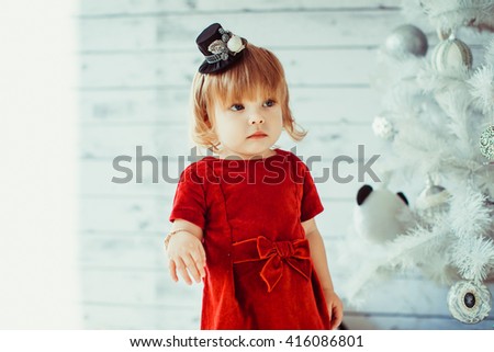 girl in red dress at the Christmas tree