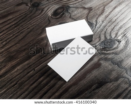 Blank business cards on dark wooden background. Mock-up of business cards for design presentations and portfolios.