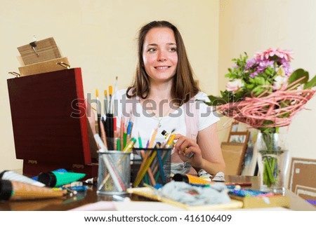 Smiling adult artist in the process of creating a new picture