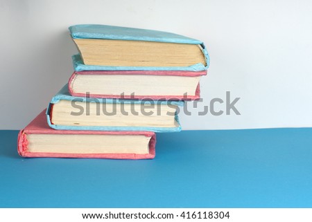 Composition with vintage old hardback books, diary, fanned pages on light background. Books stacking. Back to school. Copy Space. Education background.
