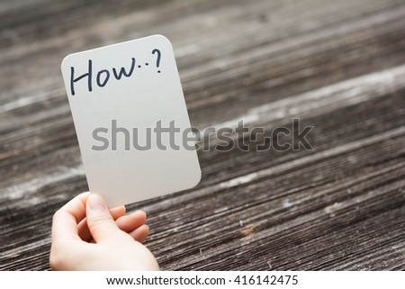 holds card with text how on old wood plate