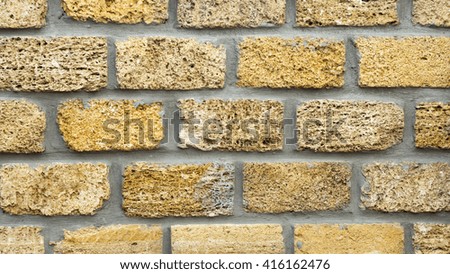 Wall of yellow coquina blocks closeup background