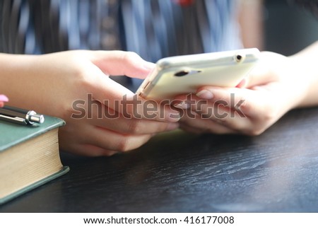  women hand use phone on table ,using mobile smart phone, Internet of things lifestyle with wireless communication and internet with smartphone.

