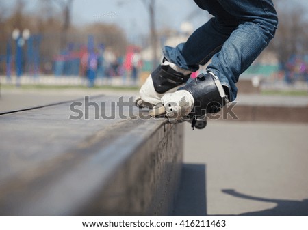Rollerblader grinding on rail in skate park outdoors. Trick is called topside soul or topsoul. Dangerous extreme skating popular among youth and teenagers. 