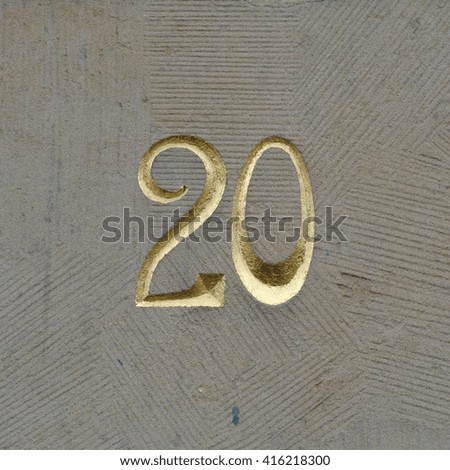 Golden house number twenty engraved in stone