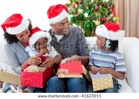 Happy Afro-American family opening Christmas presents at home