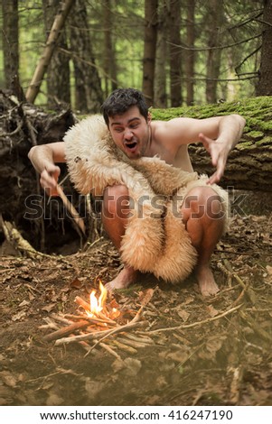 caveman produces fire in the forest, in the skin