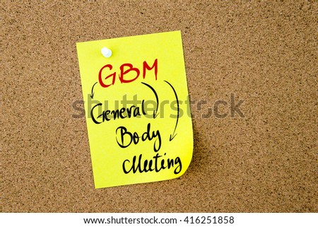 Business Acronym GBM General Body Meeting written on  yellow paper note pinned on cork board with white thumbtack, copy space available