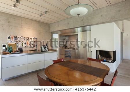 Interior of a villa, modern kitchen with wooden table, concrete walls
