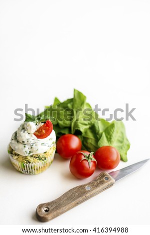 Spinach cupcakes with cream cheese frosting with fresh green onion and cherry tomatoes