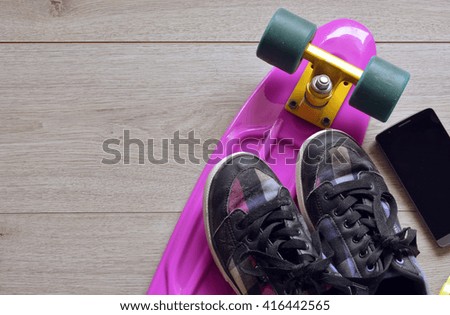 skateboard with bag, sneakers and mobile phone