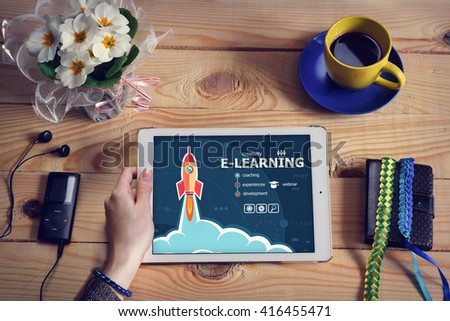 Laptop computer, tablet pc and Online e-learning concept on wooden office desk with copy space. Online e-learning design concept background with rocket. 