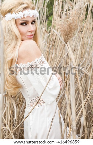 Beauty Girl Outdoors enjoying nature. Beautiful Model girl in white dress running on the Spring Field, Sun Light. Royalty-Free Stock Photo #416496859