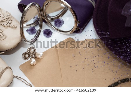 a couple piece of paper with amethyst, mirror, jewelry and hat