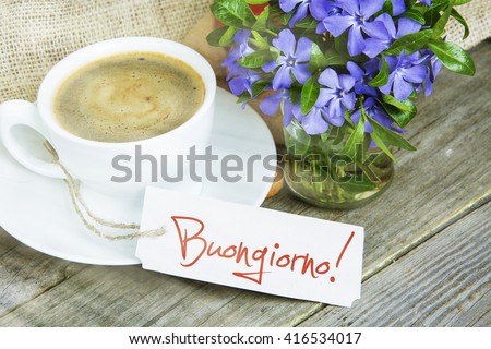 Coffee mug with Vinca flowers and notes buongiorno -  good morning on Italian. filter sunlight, toned image.