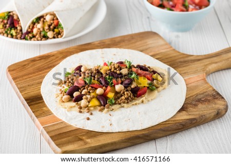 Vegan wraps with lentil, chickpea, kidney bean, peppers and hummus sauce