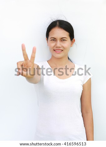 Young asian woman in T-Shirt Showing expression a two-finger victory, Selected focus at her face