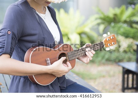 Beautiful woman are studying to play ukulele.