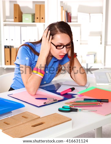 Young graphic designer working on laptop using tablet at home