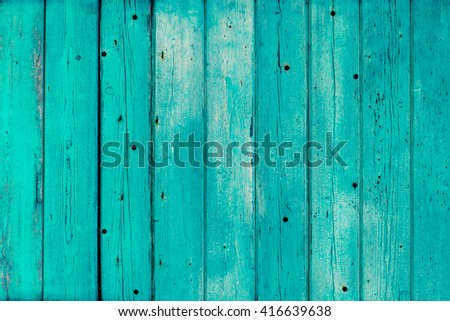 Texture of vertical wooden planks with peeling turquoise blue color paint. Detailed background photo texture.