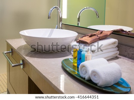 detail of a modern bathroom with white sink and towels 