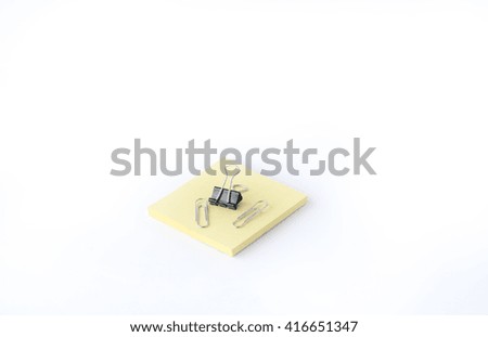 Yellow note paper and clip  isolated on white background