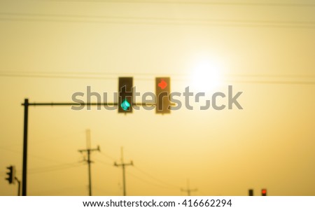 Blurry traffic lights on morning time in the city with warm tone from sunrise