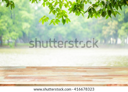 Abstract Natural wood table with Morning sun light tree lake background : Top view of plank wood for graphic stand product, interior design or montage display your product
