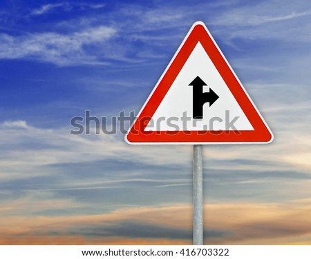 Triangle road sign the right direction on rod with cloudy sky
