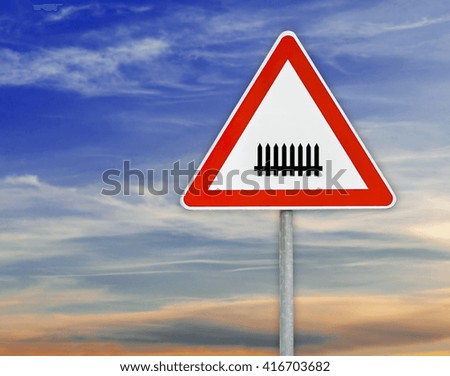 Triangle road sign rails on rod with cloudy sky