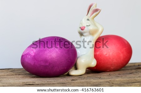 Easter eggs and bunny sculpture on wood with a white background.
