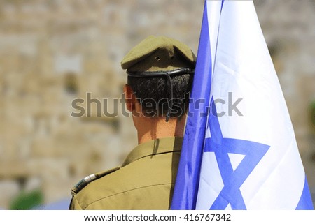 Israeli soldier with flag of Israel on blurred background of Western Wall Royalty-Free Stock Photo #416767342