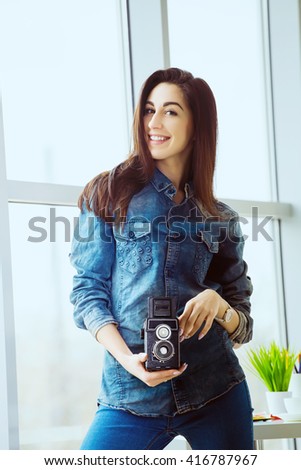 Young cute and smiling photographer and graphic designer woman at work in office