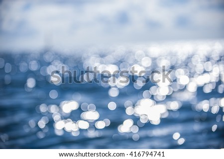 Beautiful abstract background bokeh sun light reflections on blue aqua water sailing boat