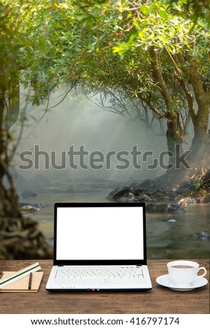 blank laptop on wooden table with natural background