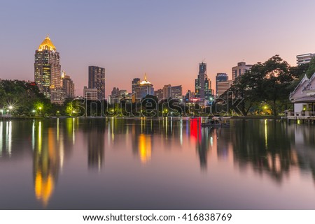 Business district cityscape from a park with twilight time from lumpini park, Bangkok Thailand