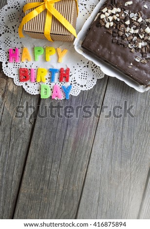 Colorful happy birthday candles, chocolate cake and Festive present boxes. invitation, sweet wish concept. space for text. filter sunlight, toned image.