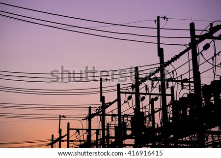 Silhouette of high power electric pole and purple twilight sky