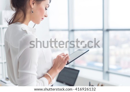 Close-up side view portrait of an employee texting, sending and reading messages during her break at the workplace.